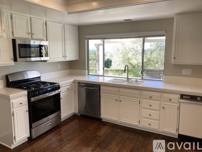 A kitchen with white cabinets and a stainless steel oven.