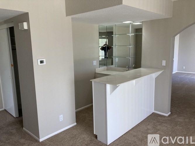 A white reception desk in a room with a glass door.