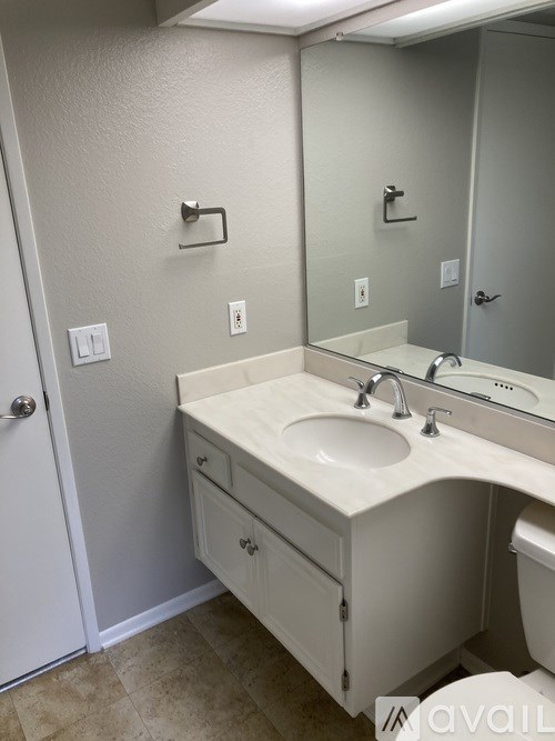 A bathroom with a sink, mirror, and toilet.
