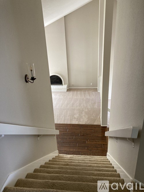 A staircase with a carpeted runner and a wooden handrail.