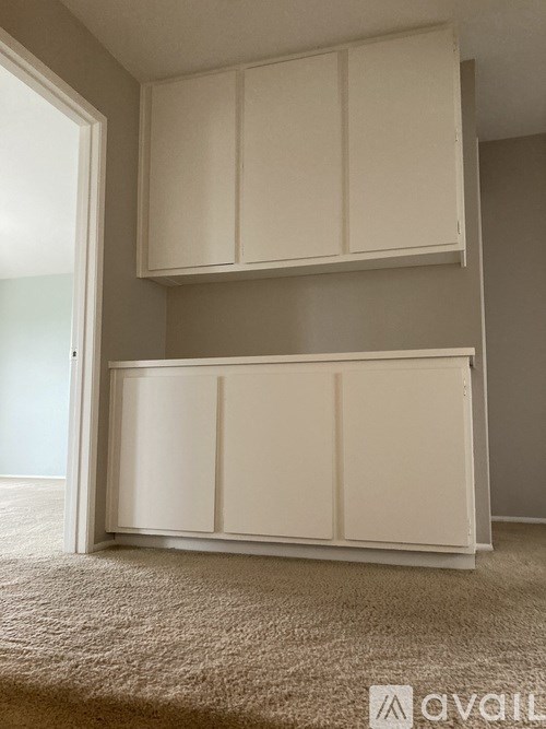 A white cabinet with two doors is mounted on a wall.