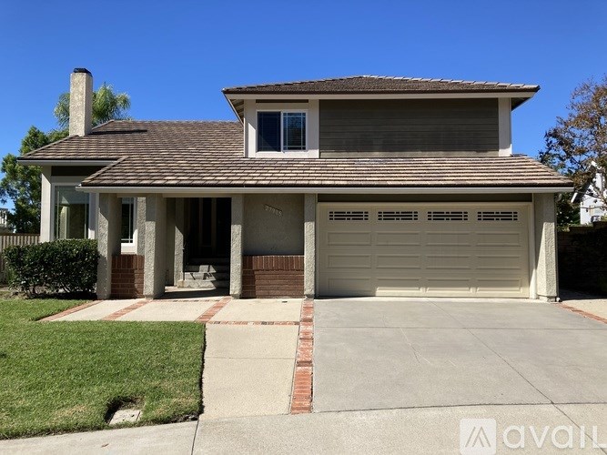 A house with a garage and a driveway in front.