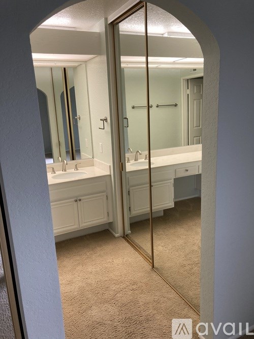 A bathroom with a large mirror and a sink.