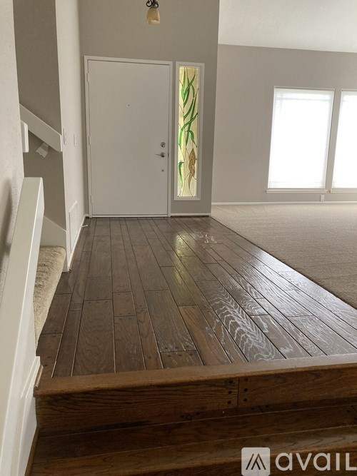 A room with a wooden floor and a white door.