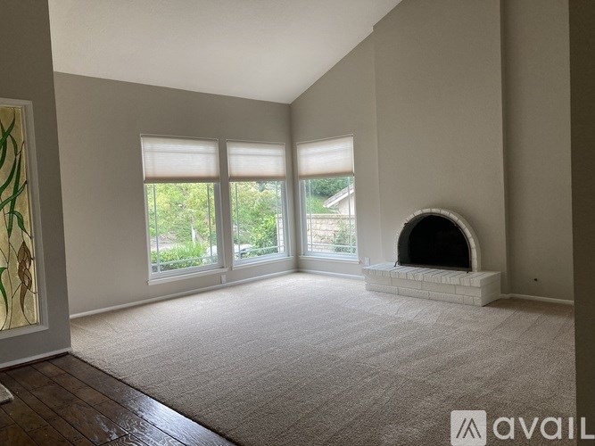 A spacious living room with a fireplace and large windows.