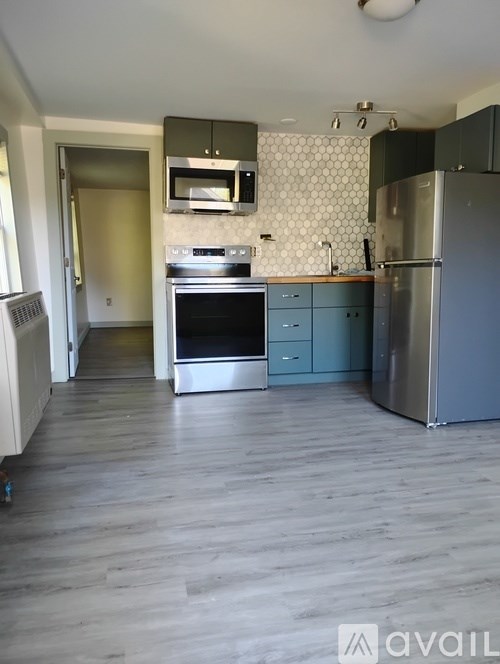 A kitchen with a refrigerator, oven, and microwave.