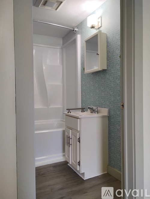 A small white bathroom with a sink and a cabinet.