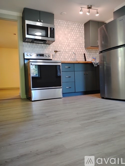 A kitchen with a stainless steel refrigerator, microwave, and oven.