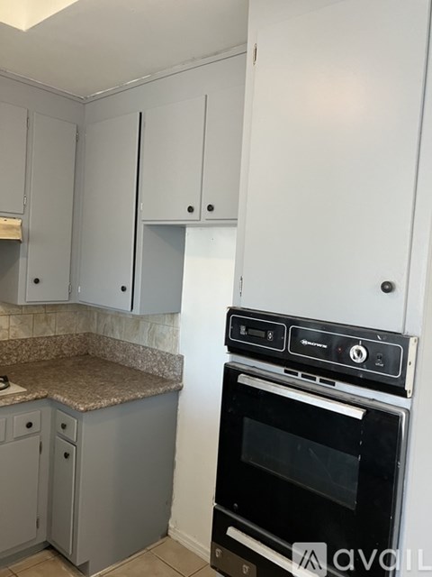 A kitchen with a white oven and grey cabinets.