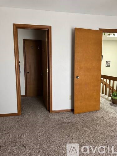 Two brown doors in a white room.