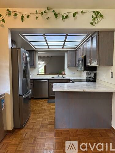 A kitchen with wooden floors and a skylight.