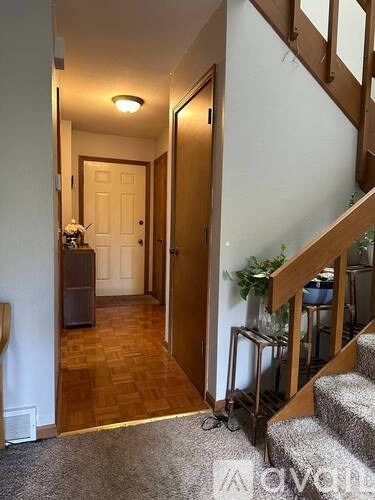 A hallway with a staircase and a door.