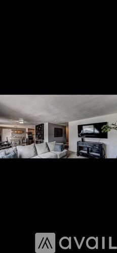 A modern living room with a white couch and a television.