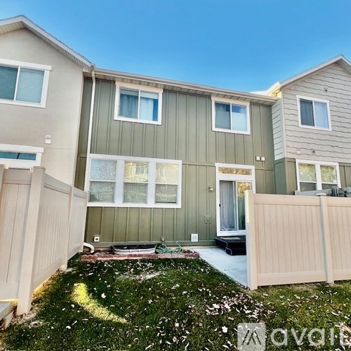 A row of houses with green siding and white trim.