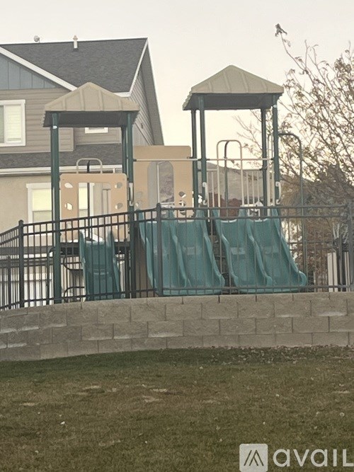 A playground with a green slide and a gazebo.