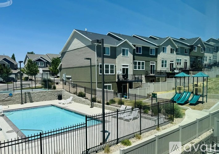 A row of houses with a pool in the foreground.