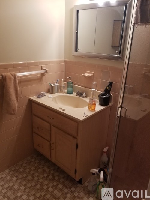 A bathroom with a sink, mirror, and towel.
