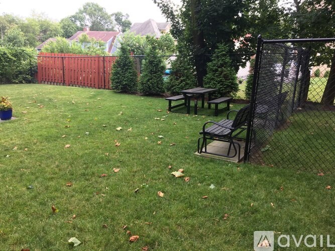 A backyard with a picnic table and a black mesh screen.