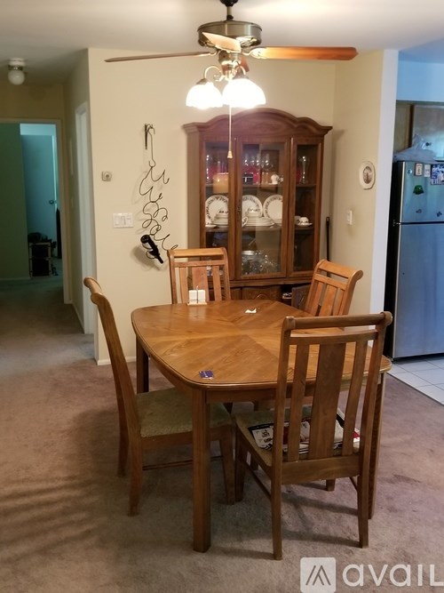 A wooden dining table with four chairs and a hanging light fixture above it.