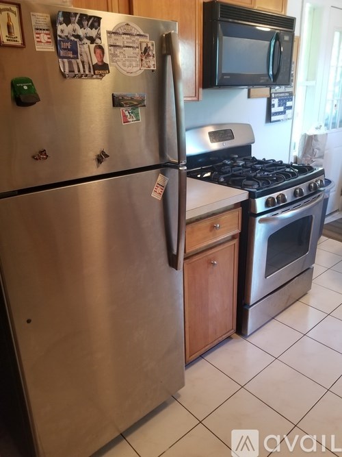 A stainless steel refrigerator with a green button on it.
