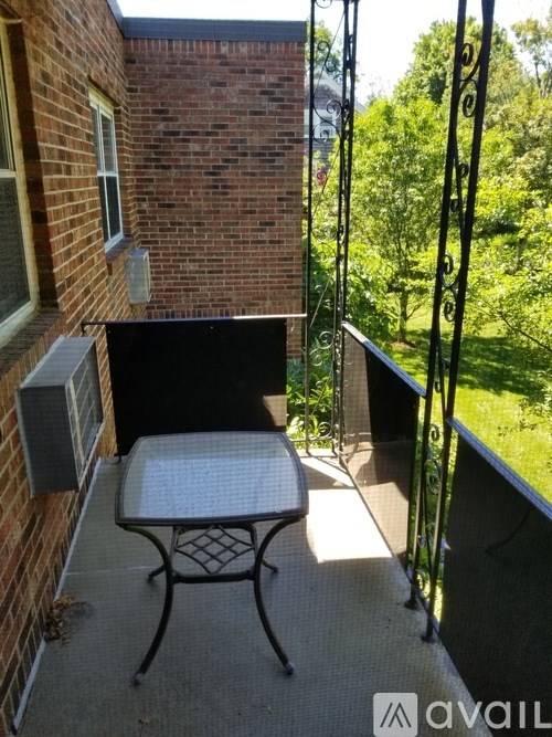 A patio with a table and chairs overlooking a green lawn.