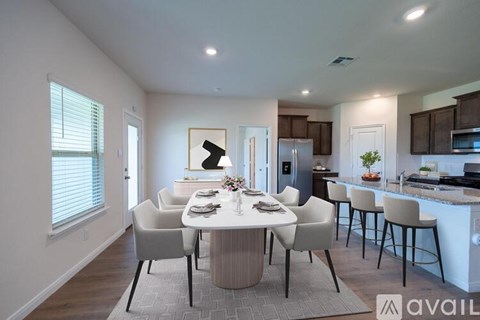 A modern dining room with a white table and chairs.