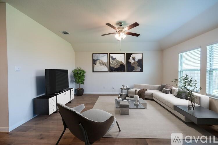 A living room with a brown chair, a white couch, and a television.