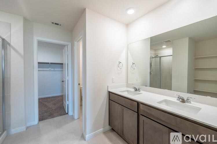 A bathroom with a double sink vanity and a large mirror.