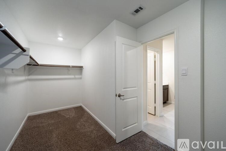 A room with a carpeted floor and a white door.