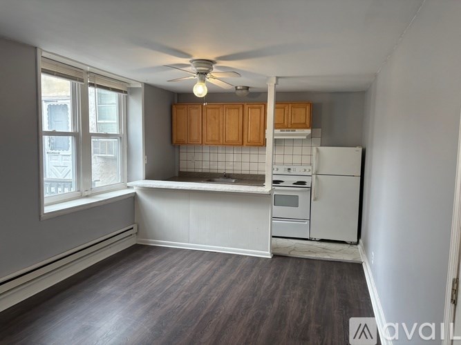 A kitchen with a white fridge and wooden cabinets.