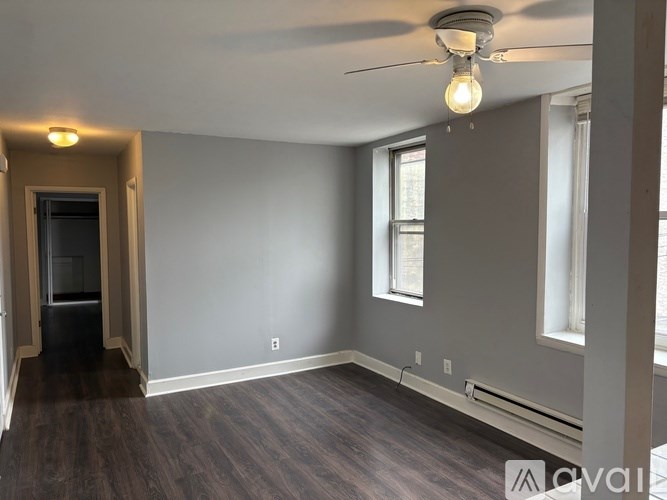 A room with a ceiling fan and a window.
