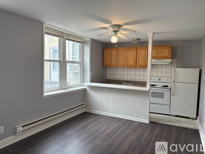 A kitchen with a white refrigerator and wooden cabinets.