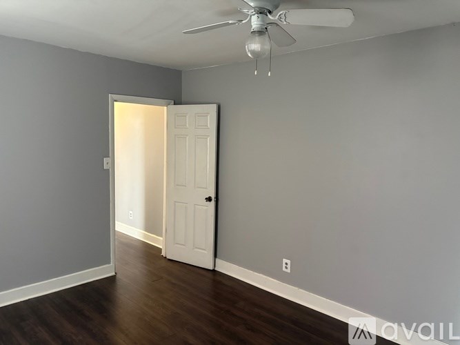 A room with a ceiling fan and a door.