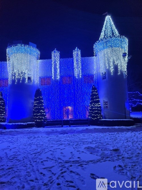 A castle-like structure is lit up with blue lights at night.