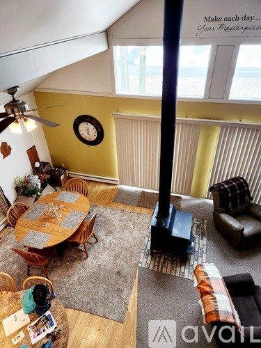A living room with a table, chairs, and a fan.