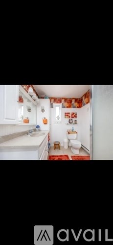 A bathroom with a toilet, sink, and a shower curtain.