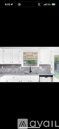 A black and white photo of a kitchen with a sink and cabinets.