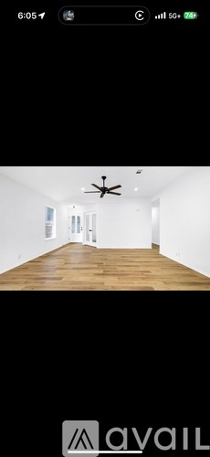 A room with wooden flooring and a ceiling fan.