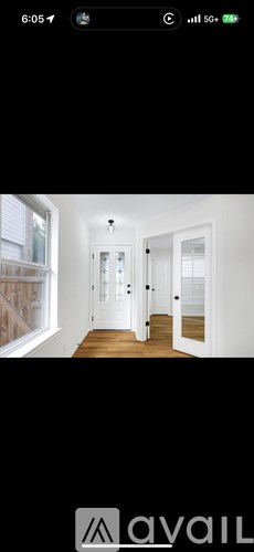 A hallway with white doors and a wooden floor.