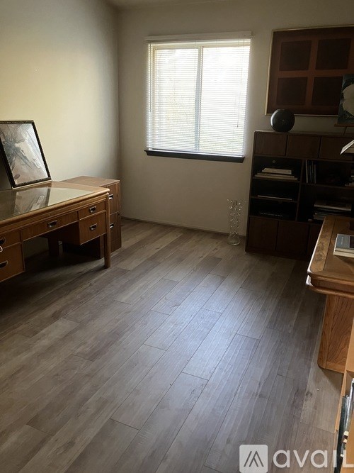 A room with wooden flooring and furniture.
