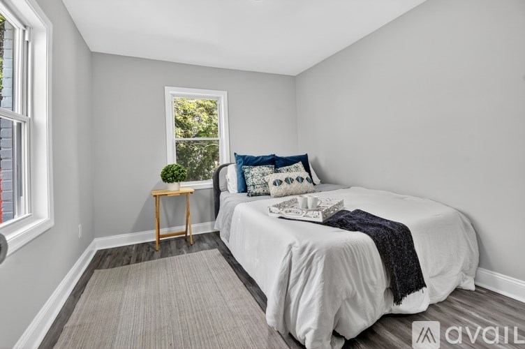 A bedroom with a bed, pillows, and a blanket.