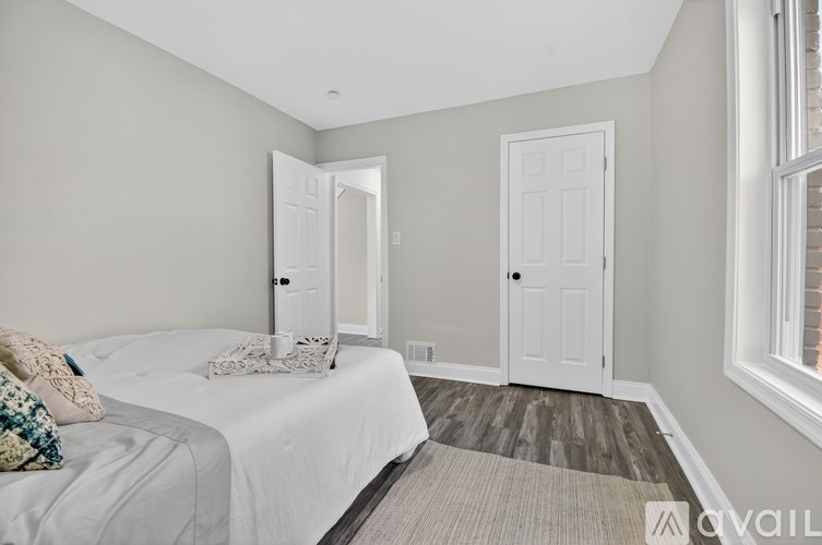 A bedroom with a bed, pillows, and a window.