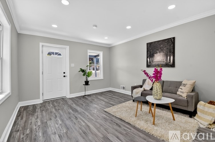 A living room with a grey couch, a white coffee table, and a painting on the wall.