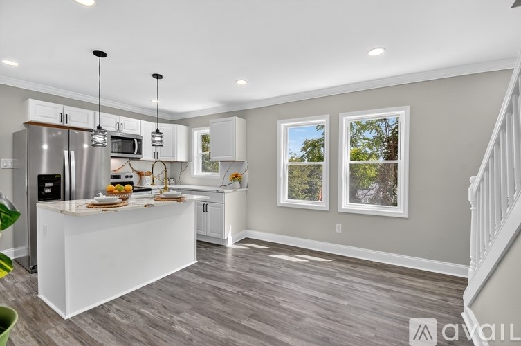A kitchen with a white island and stainless steel appliances.