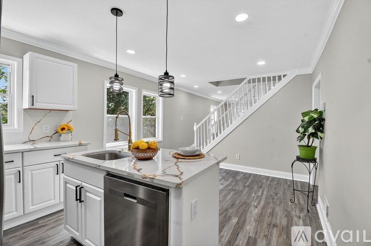A kitchen with a stainless steel dishwasher and a white countertop.
