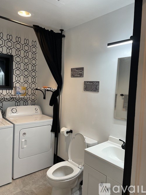 A bathroom with a toilet, sink, and a mirror.
