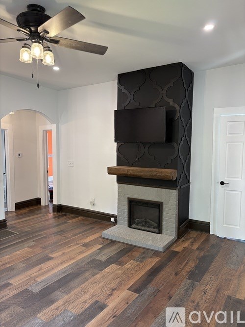 A modern living room with a fireplace and a television mounted above it.