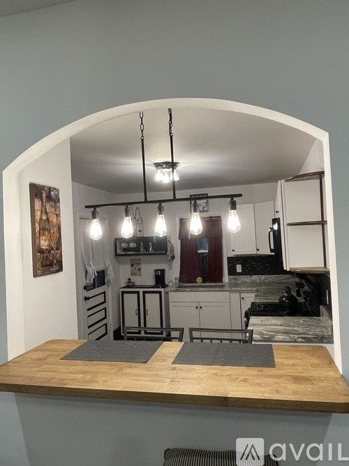 A kitchen with a wooden countertop and pendant lights.