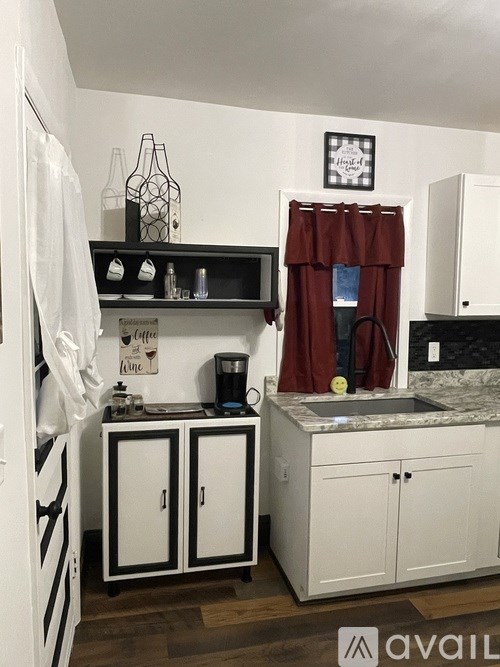A kitchen with white cabinets and a black and white striped fridge.