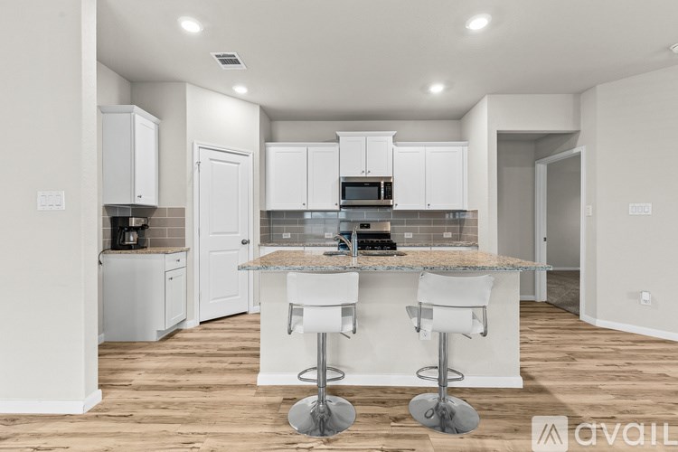 A kitchen with white cabinets and a granite countertop.